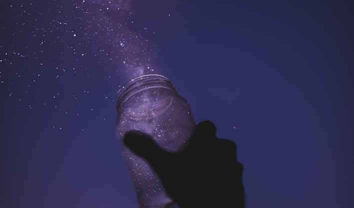 person holding glass jar