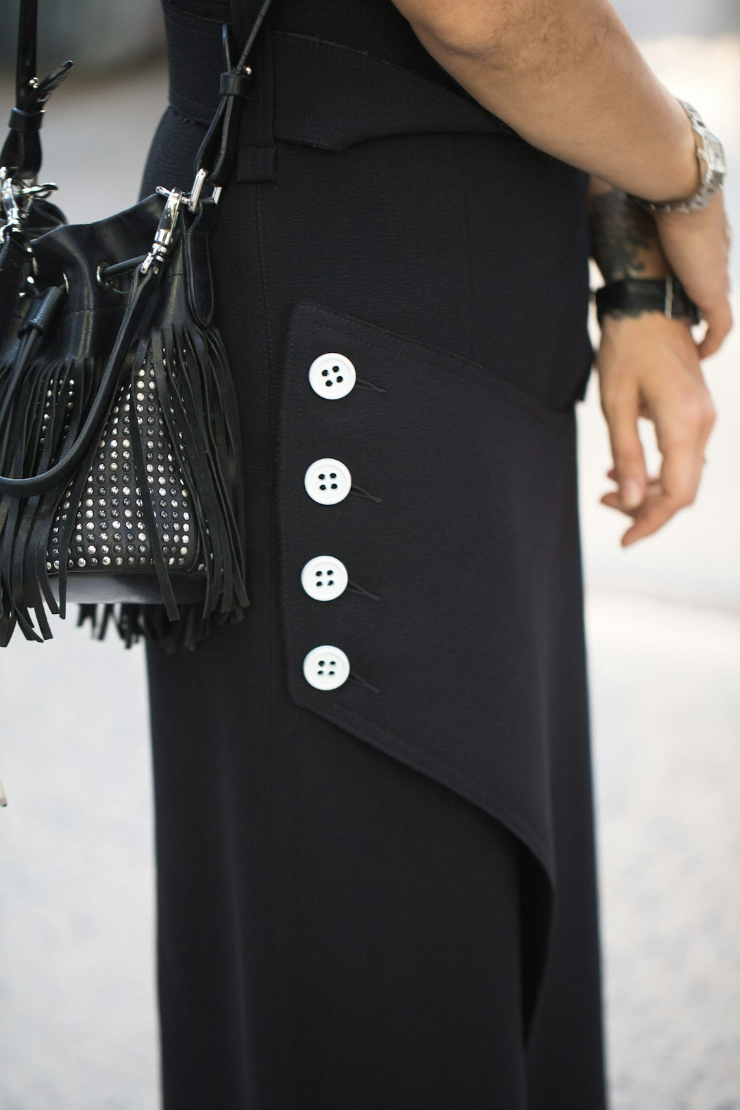 woman in black dress and crossbody bag with fringe