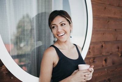 Woman holding a cup of herbal tea with a relaxed and happy expression