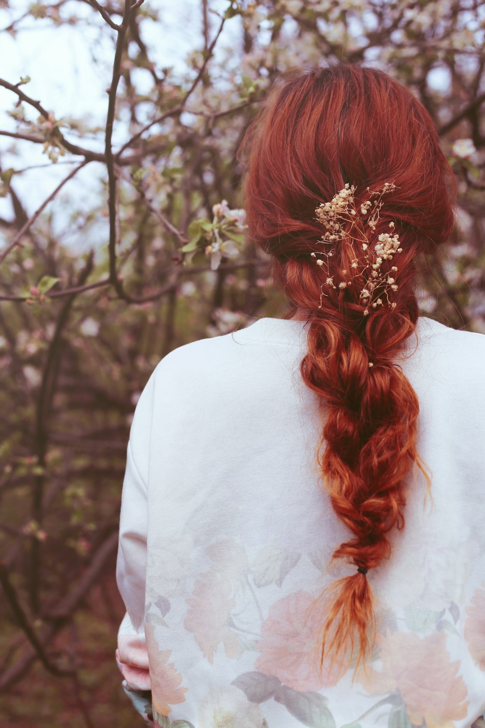 woman facing pink flowering tree