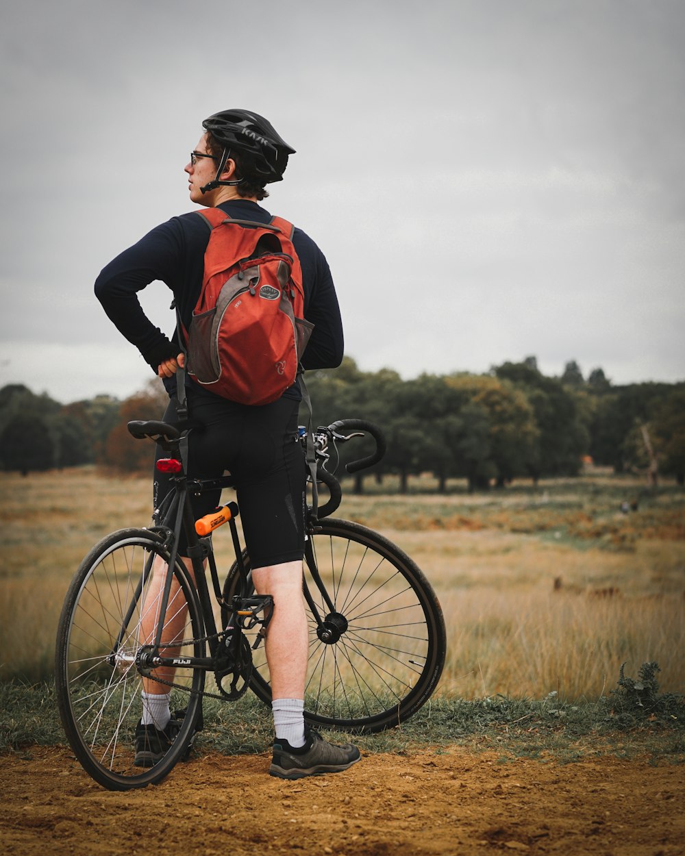 man holding road bike in front of trees