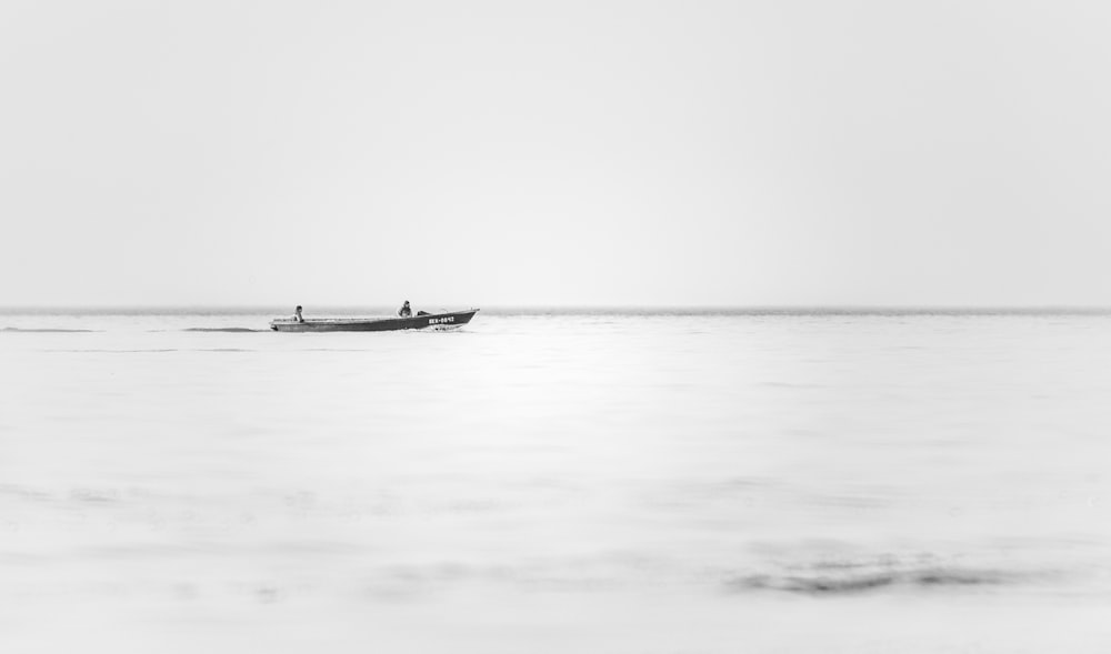 grayscale photography of boat on body of water