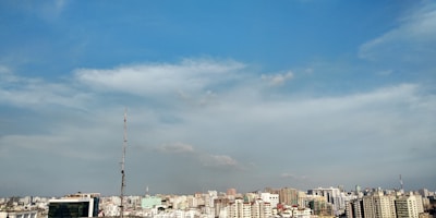 A vibrant cityscape with diverse residential and commercial buildings under a clear sky.