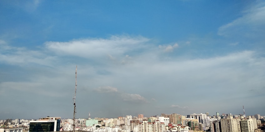 A vibrant cityscape of Uttar Pradesh with diverse residential and commercial buildings under a clear sky.