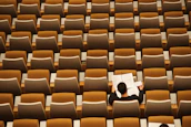Portrait of a juror thoughtfully reviewing opera scores in a classic study room.