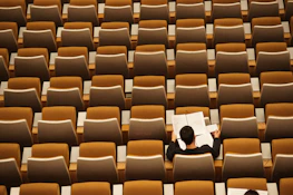 Portrait of a juror thoughtfully reviewing opera scores in a classic study room.