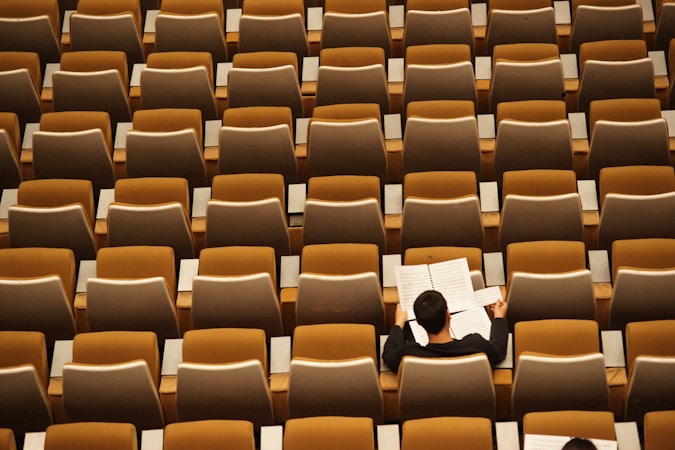 A student studying alone in a quiet university lecture hall, reflecting the personal support model Nevada State University points to