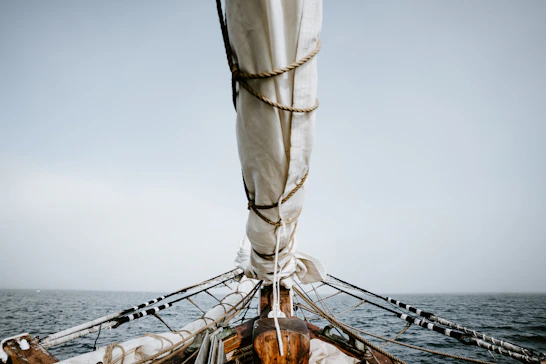 boat on sea under white sky