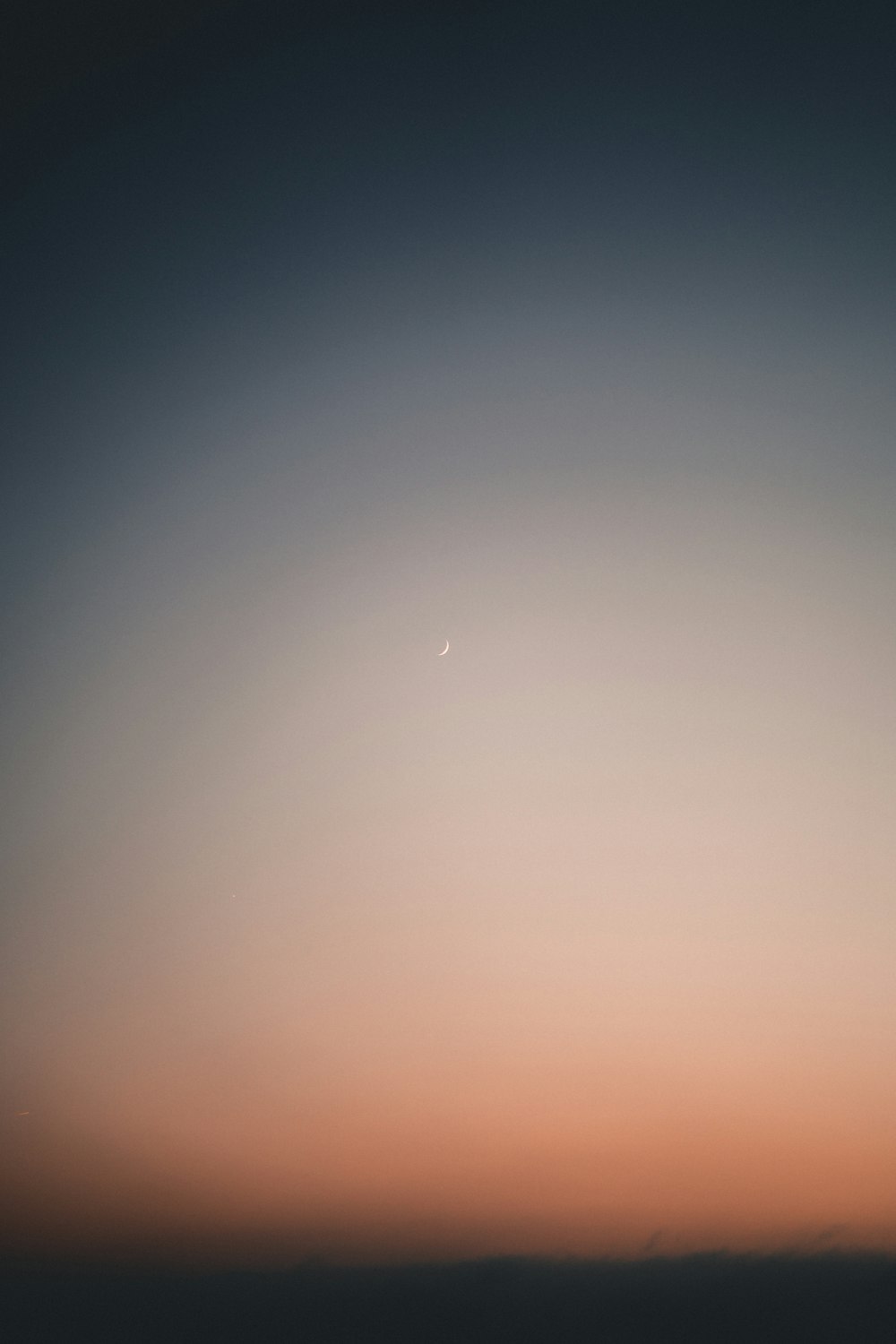 a plane flying in the sky at sunset