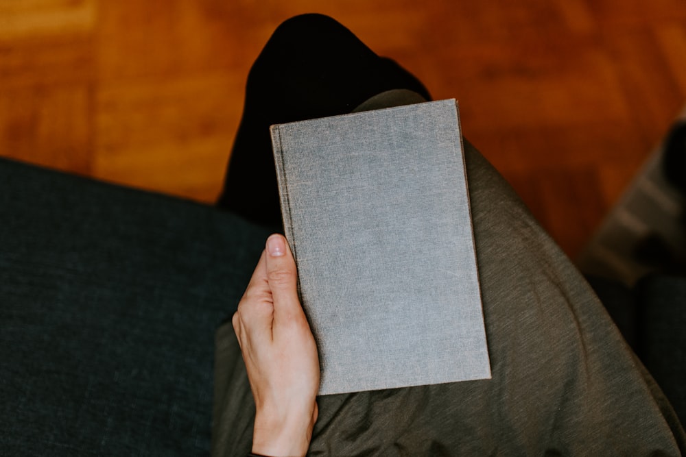 person holding gray book
