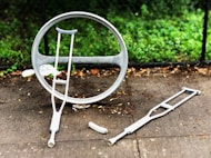 two gray crutches on concrete pavement during daytime