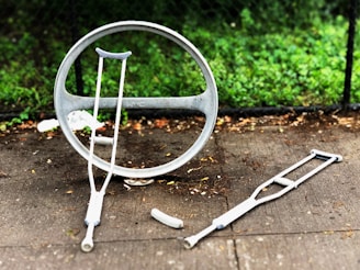 two gray crutches on concrete pavement during daytime