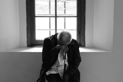 man sits on chair near window