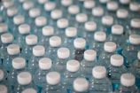 Close-up of a stainless steel bottled water filling machine with clear water bottles lined up.