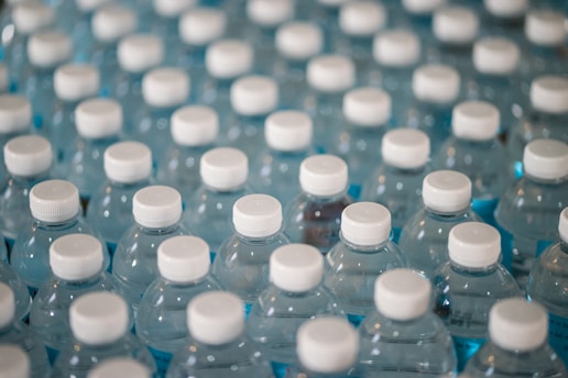 Clear water bottles stacked neatly ready for delivery in a bright warehouse.