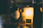 A close-up of a golden gin bottle with a warm, inviting glow in a cozy bar setting.