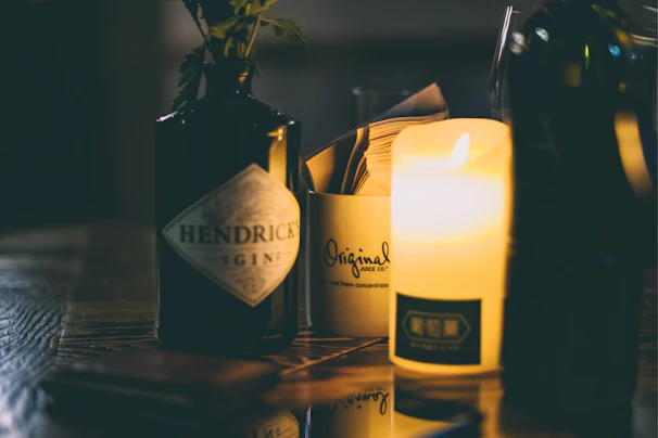 Dimly lit distillery scene showing copper stills gleaming under low light, with shadows emphasizing the craftsmanship behind genever.