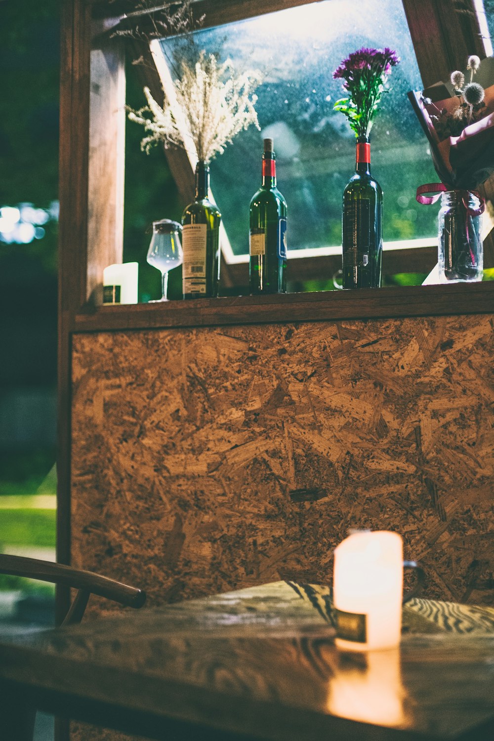 several wine bottles on brown wooden board during nighttime