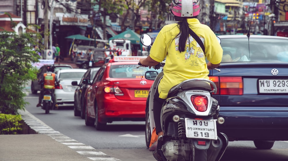 person riding black and white motor scooter