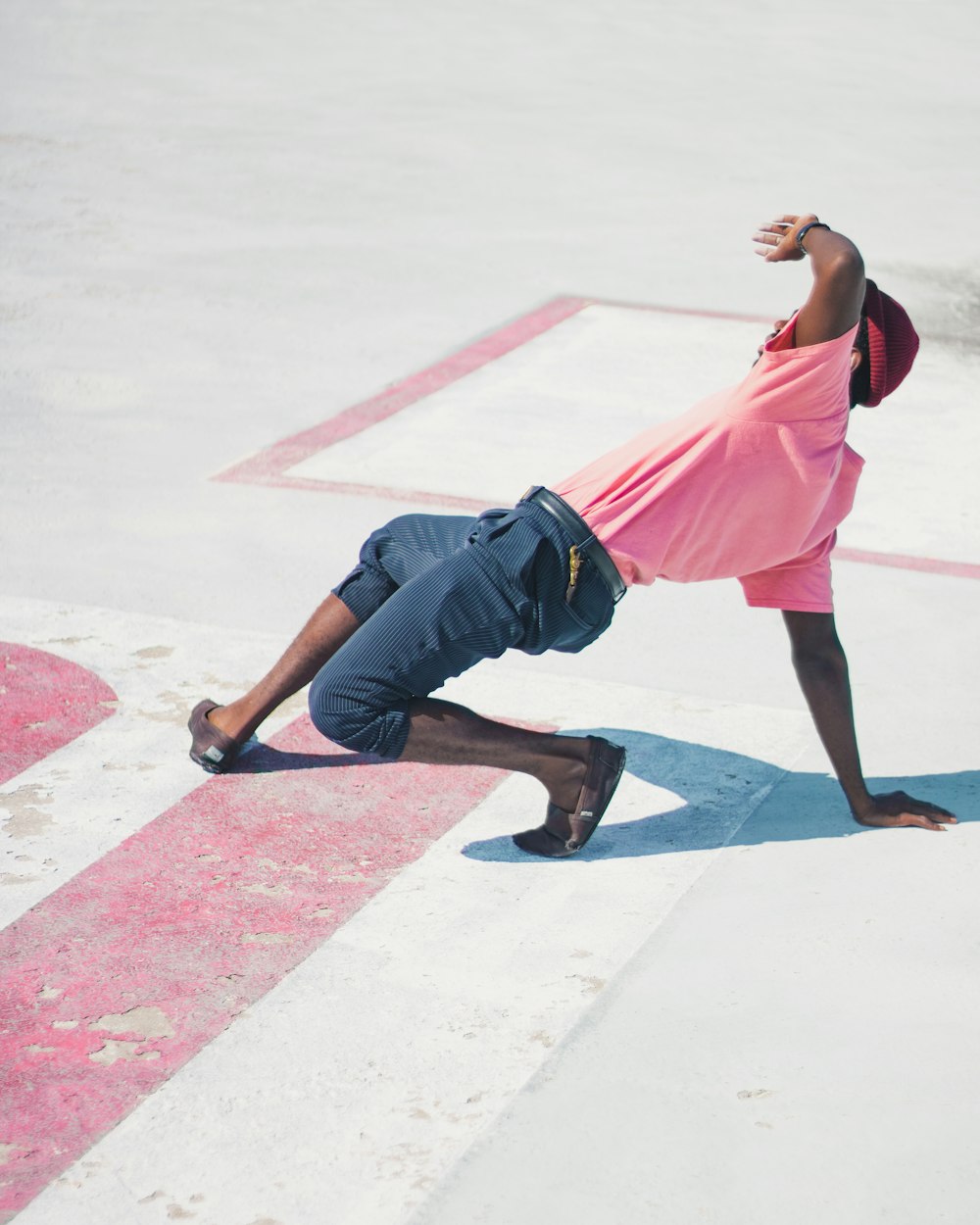 Mann im rosa T-Shirt macht Tanzbewegung