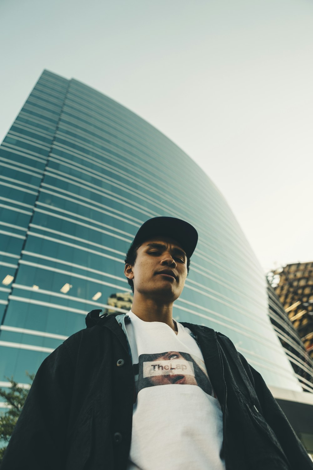 man standing beside high-rise building