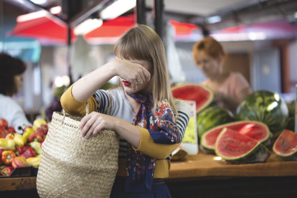 woman carrying woven bag in market