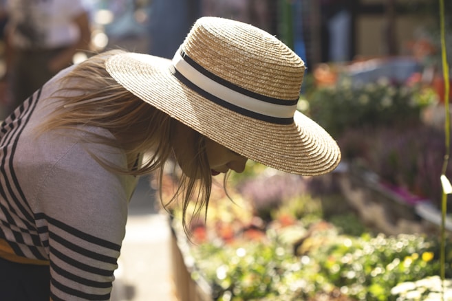 woman wearing brown sunhat working in garden