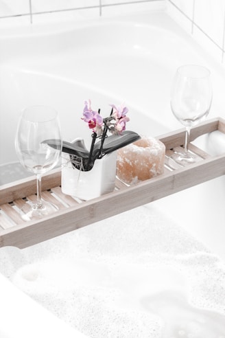 a clean bathtub with two wine glasses on tray