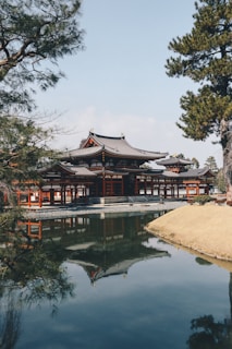 A tranquil pond reflecting the temple's architecture under a clear sky.