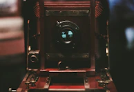 A close-up of a vintage film camera lens reflecting a scenic French countryside.