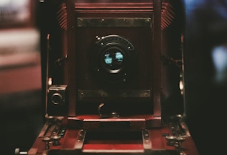 Close-up of a vintage camera lens reflecting a scenic landscape.