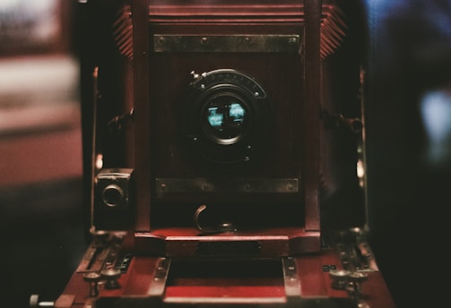 Close-up of a vintage camera lens reflecting a vibrant outdoor scene.