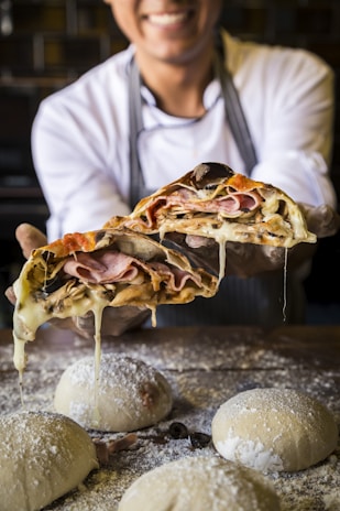 A smiling chef preparing dough for one of the signature pizzas at tlapapizzas in Martinez de la Torre.