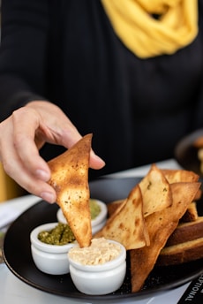 person eating nachos with sauce