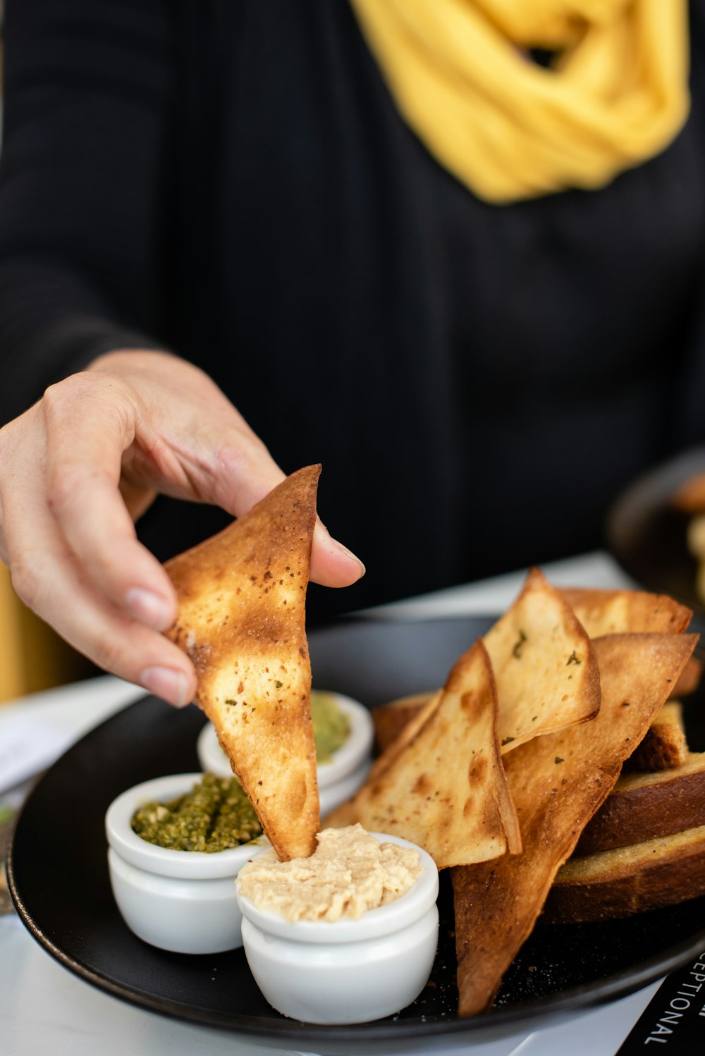 person eating nachos with sauce