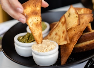 person eating nachos with sauce