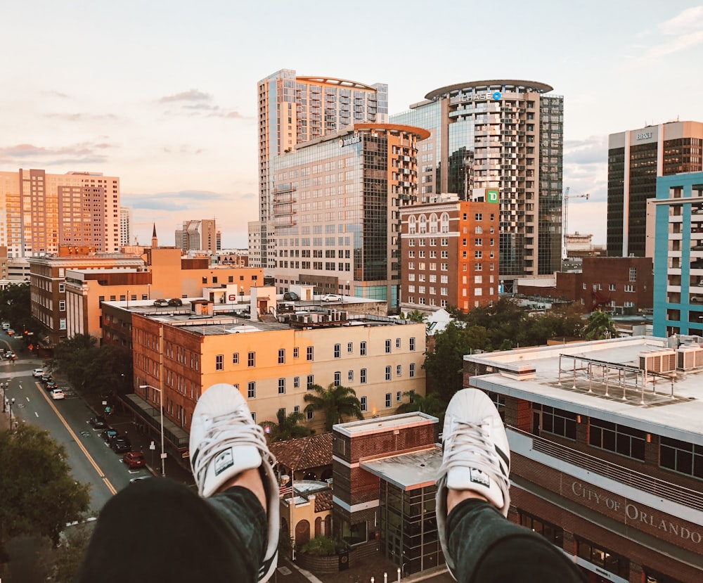 person in pair of white low-top s