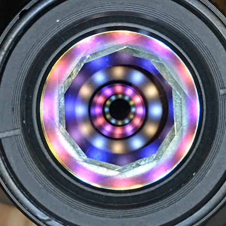 Top-down view of a geometric mandala resin pour with vibrant rainbow colors and crisp white 3d-printed template lines, polished epoxy surface.