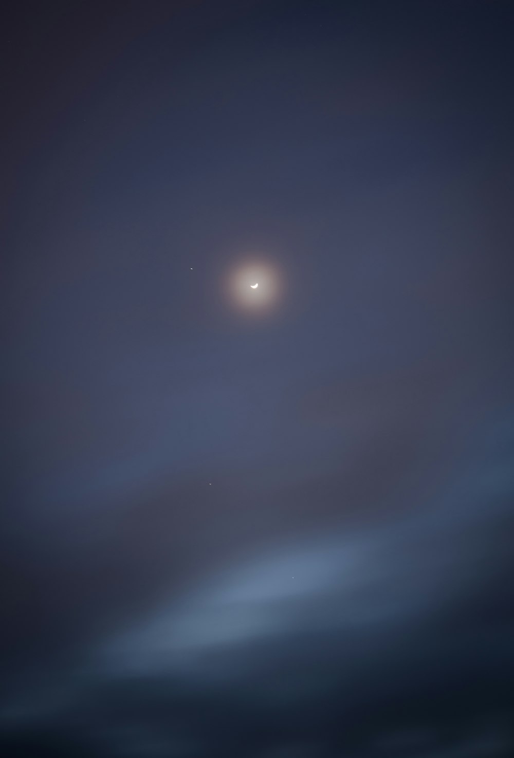 view of moon surrounded with dark clouds