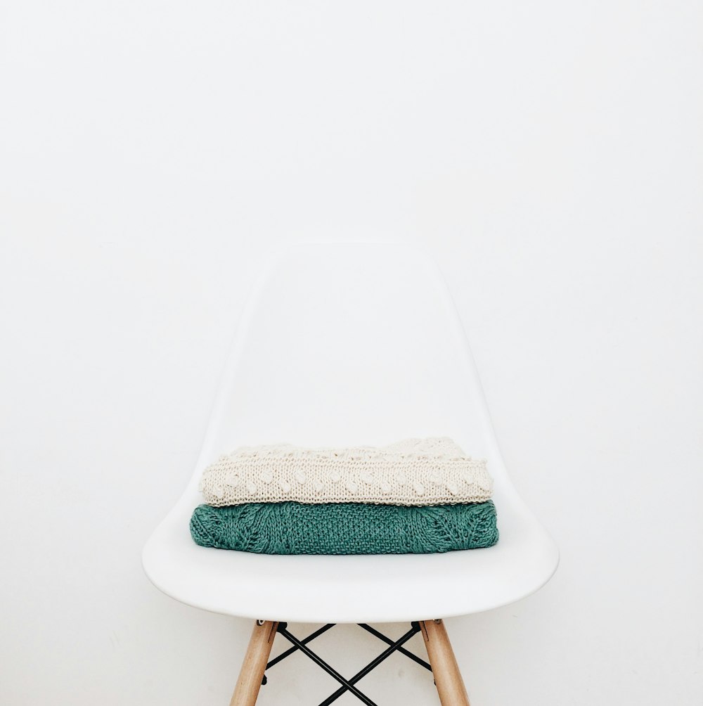 white and teal textile on white stool