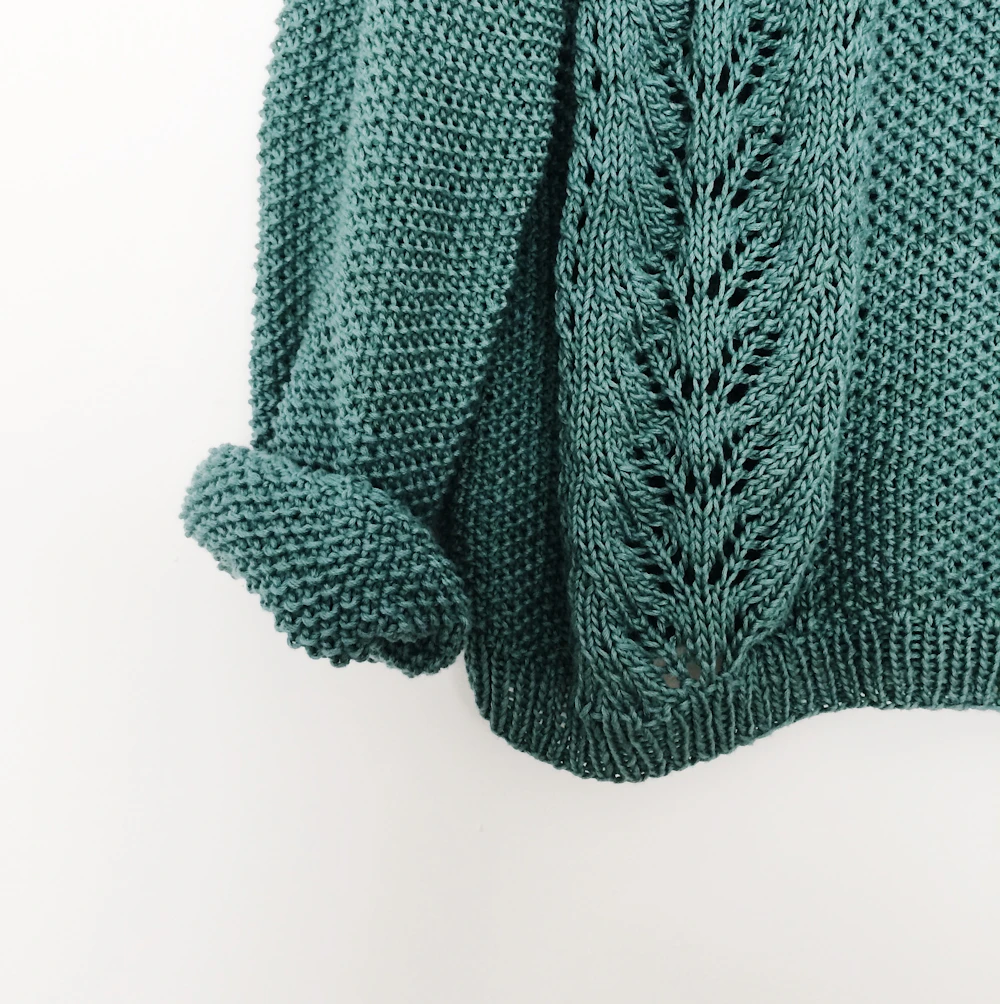 Teal lace-pattern knit sweater close-up