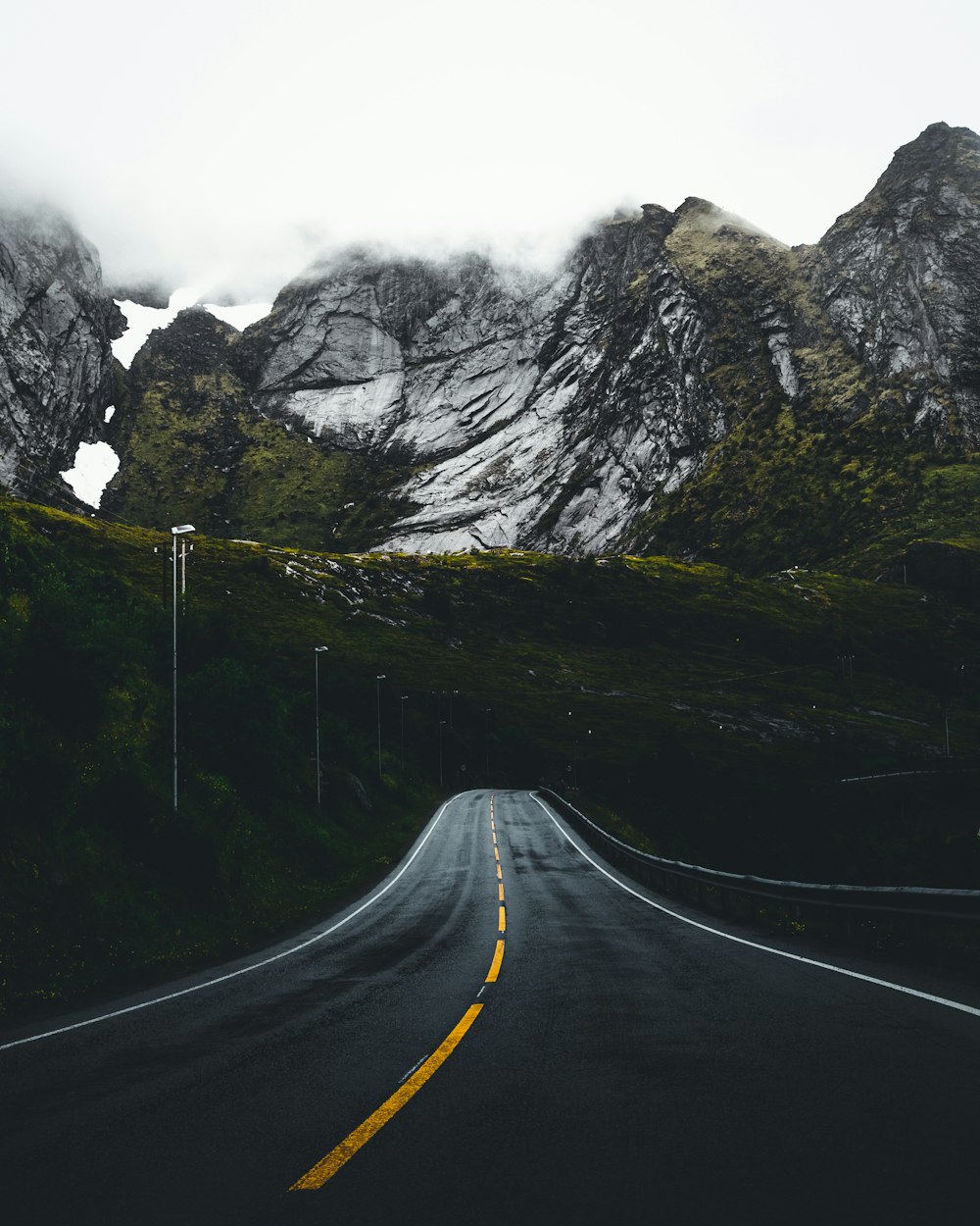 asphalt road leading to mountains