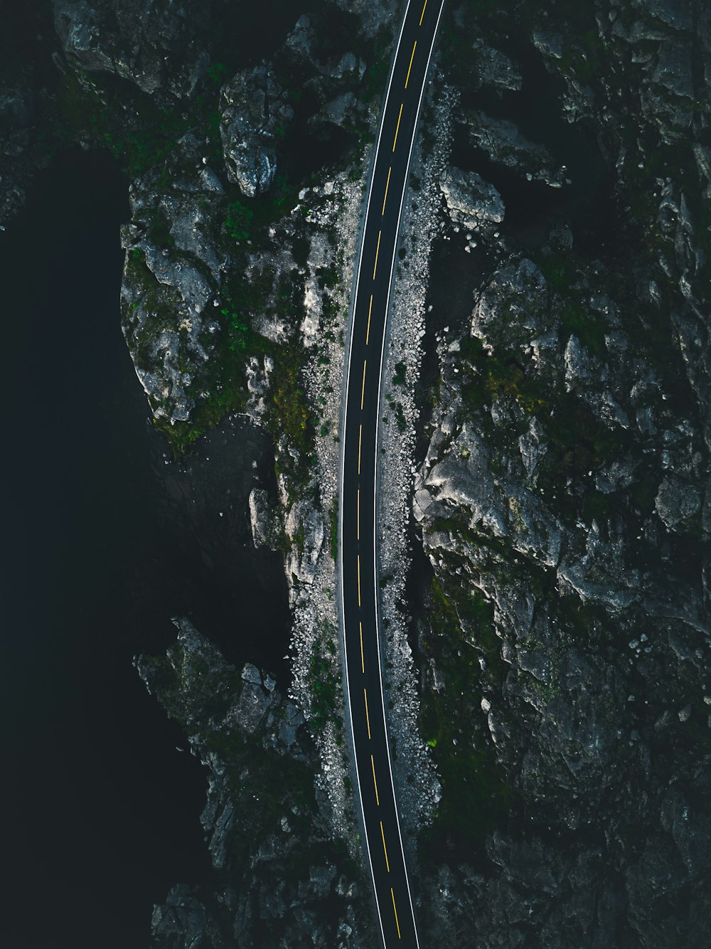 Photographie de vue aérienne d’une route en béton près d’une falaise