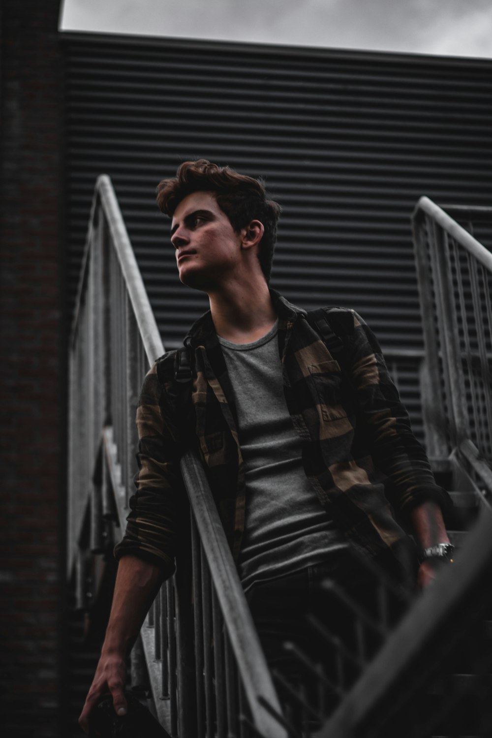 man standing on gray metal stairs