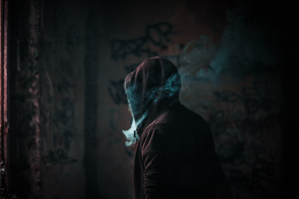 person in hoodie smoking