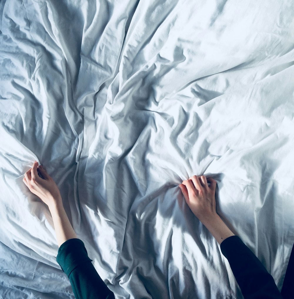 person holding white bedspread