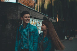 A mentor and a young adult walking together outdoors, engaged in a meaningful conversation.