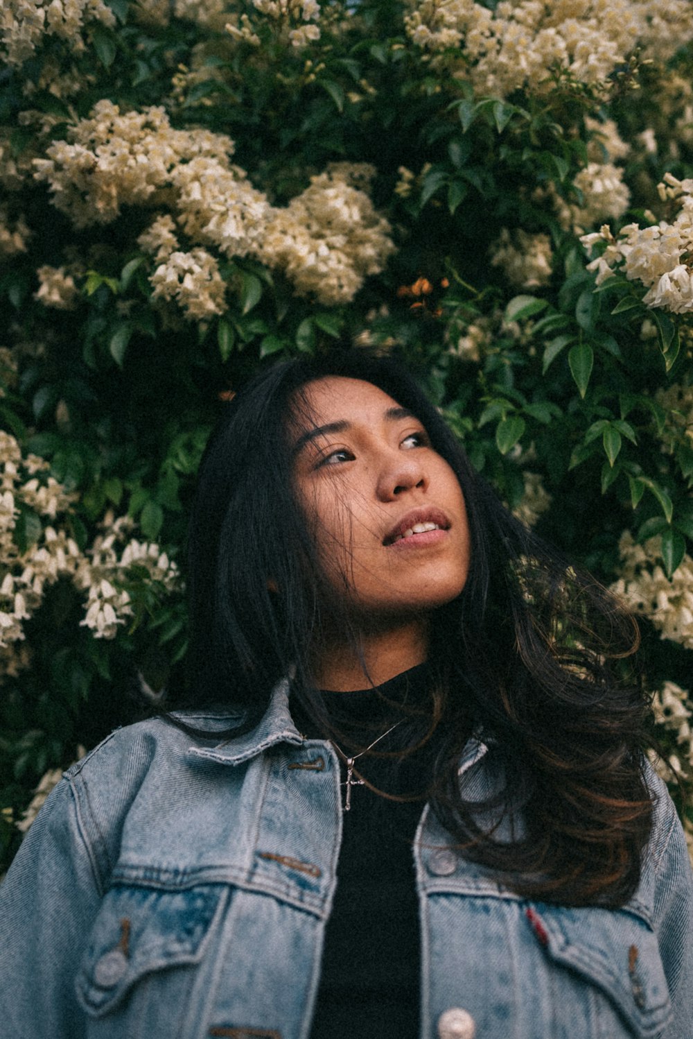 Mulher em pé perto de flores brancas de pétalas