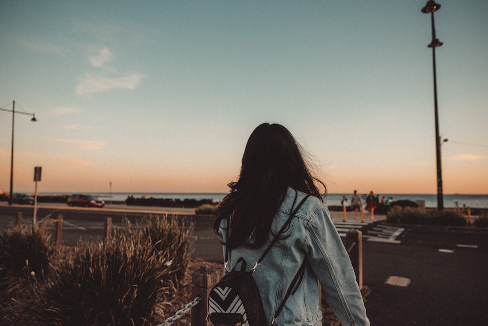 woman wearing blue jacket standing at daytime