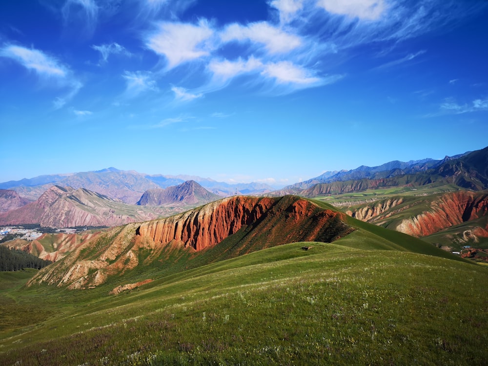 green grass covered mountain under blue sky